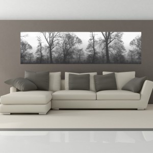 Fototapeta panoramiczna z drzewami umieszczona nad kanapą w salonie